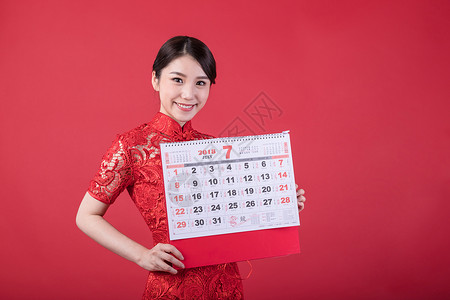 7月的节日新春手持日历的东方美女背景