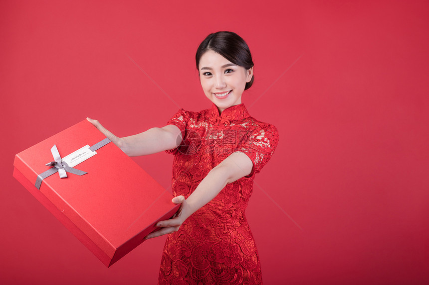 新年手递礼物的旗袍美女图片