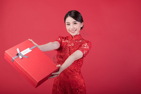 春节手礼盒提袋新年手递礼物的旗袍美女背景