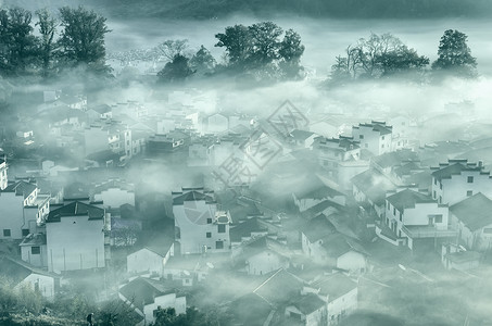 烟青色薄雾下的婺源村庄背景