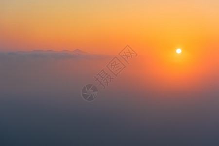 气候现象雾气朦胧中的日出与远山背景