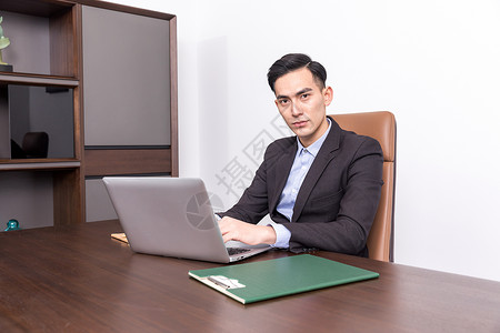 总裁室坐在办公桌前工作的商务人士背景