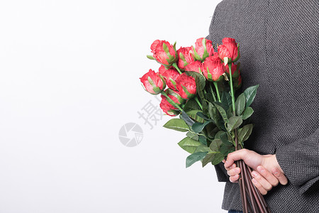手拿玫瑰花的男性背影高清图片