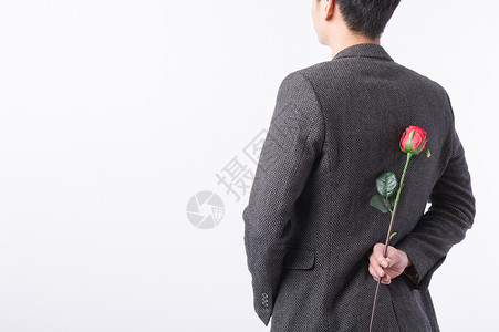 手拿玫瑰花的男性背影背景图片