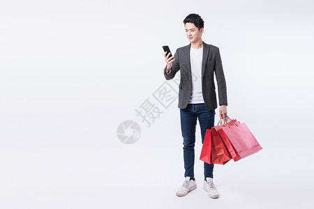 提着购物袋打电话的年轻男性背景图片