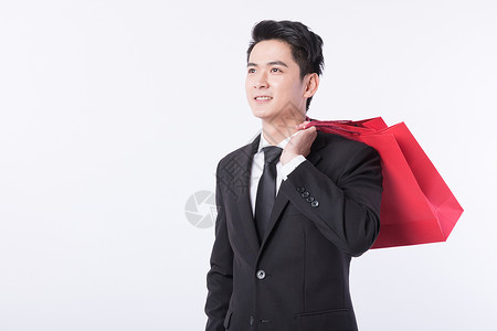 提着购物袋开心购物的年轻男子背景图片