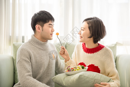 爱心签沙拉居家情侣在沙发上吃蔬菜沙拉背景