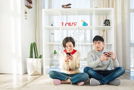 年轻情侣在家玩手机图片
