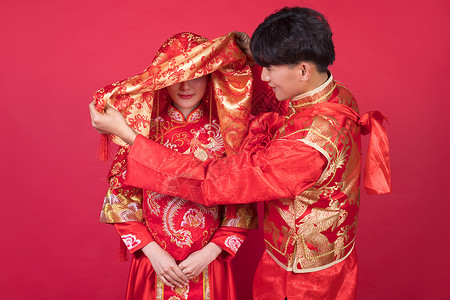 结婚夫妇传统中式婚礼新郎掀起新娘的红盖头背景