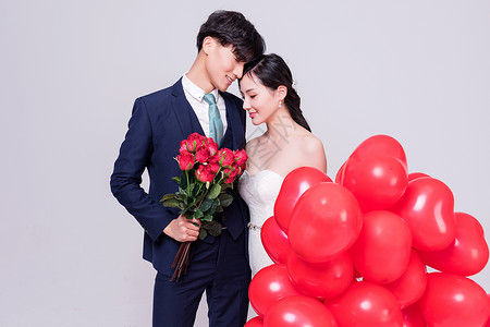 情侣婚纱手持爱心气球亲密动作图片