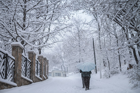 行走中的人冬天在大雪中行走的人背景