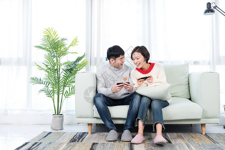 游戏情侣素材年轻情侣在客厅玩手机游戏背景