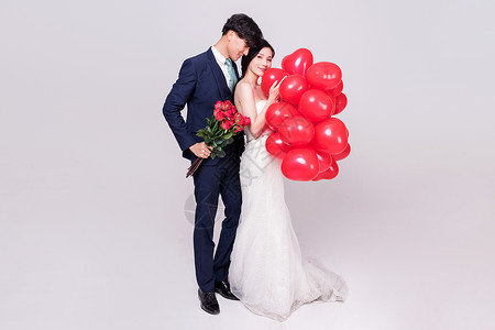 情侣婚纱手持爱心气球玫瑰花动作图片