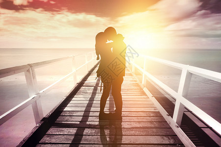 木桥晚霞下的情侣背景图片
