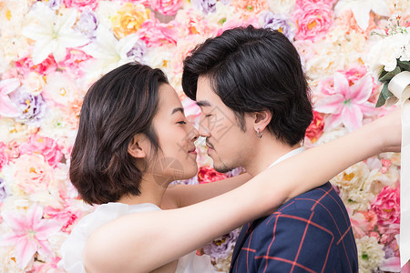韩式女花墙前的幸福年轻夫妻背景