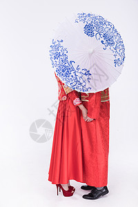 中式礼袍的年轻夫妻撑伞图片