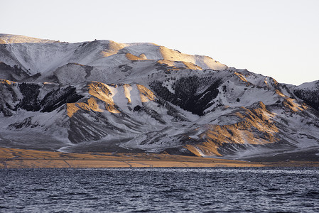 雪地光影新疆赛里木湖冬季雪景日照金山背景