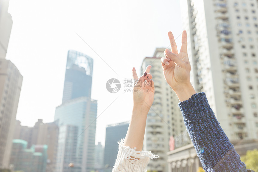 城市街头情侣比耶高举特写图片