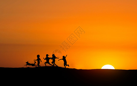 奔跑的小狗夕阳下玩耍的小孩剪影设计图片
