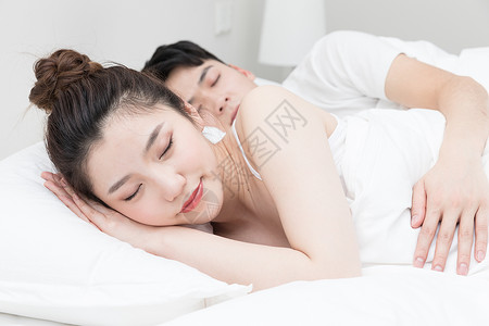 情侣躺着正在睡觉的年轻女性背景