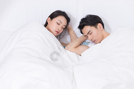 年轻夫妻拥抱躺床上休息高清图片
