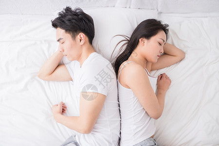 躺在床上的情侣年轻夫妻背对背躺在床上背景