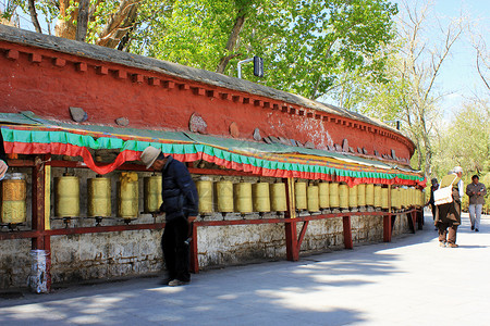 西藏信徒拉萨街头转经筒背景