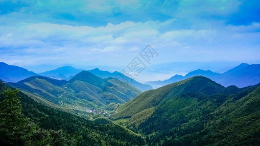 蓝天白云下起伏的山峦山脉背景图片