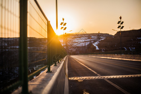 攀越护栏夕阳下的公路背景