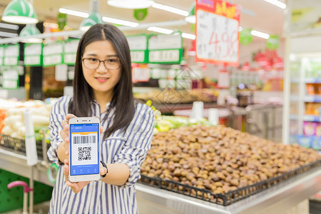 超市火锅节超市年轻女性手拿手机支付背景