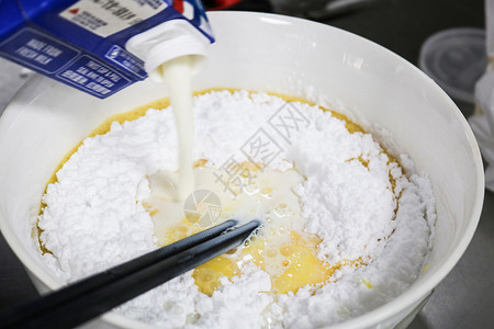 筷子搅拌面粉和鸡蛋和牛奶背景