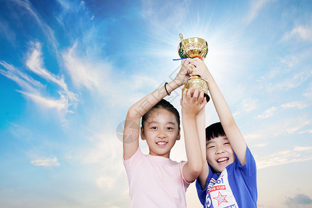 获奖的男孩学生胜利举起奖杯设计图片
