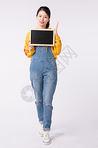 站着拿小黑板展示的活力女性图片站着拿小黑板展示的活力女性背景