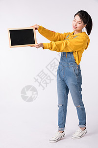 站着拿小黑板展示的活力女性图片站着拿小黑板展示的活力女性背景