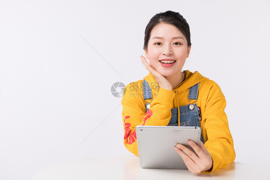 坐着使用平板电脑的时尚女生图片
