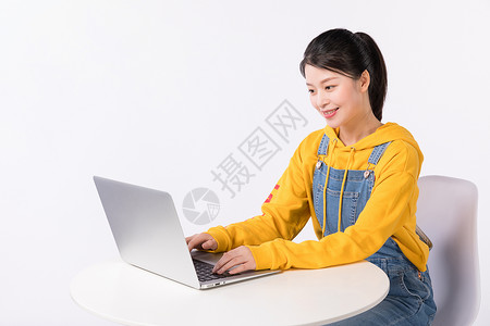 打饭学生坐在椅子上使用电脑的学生背景