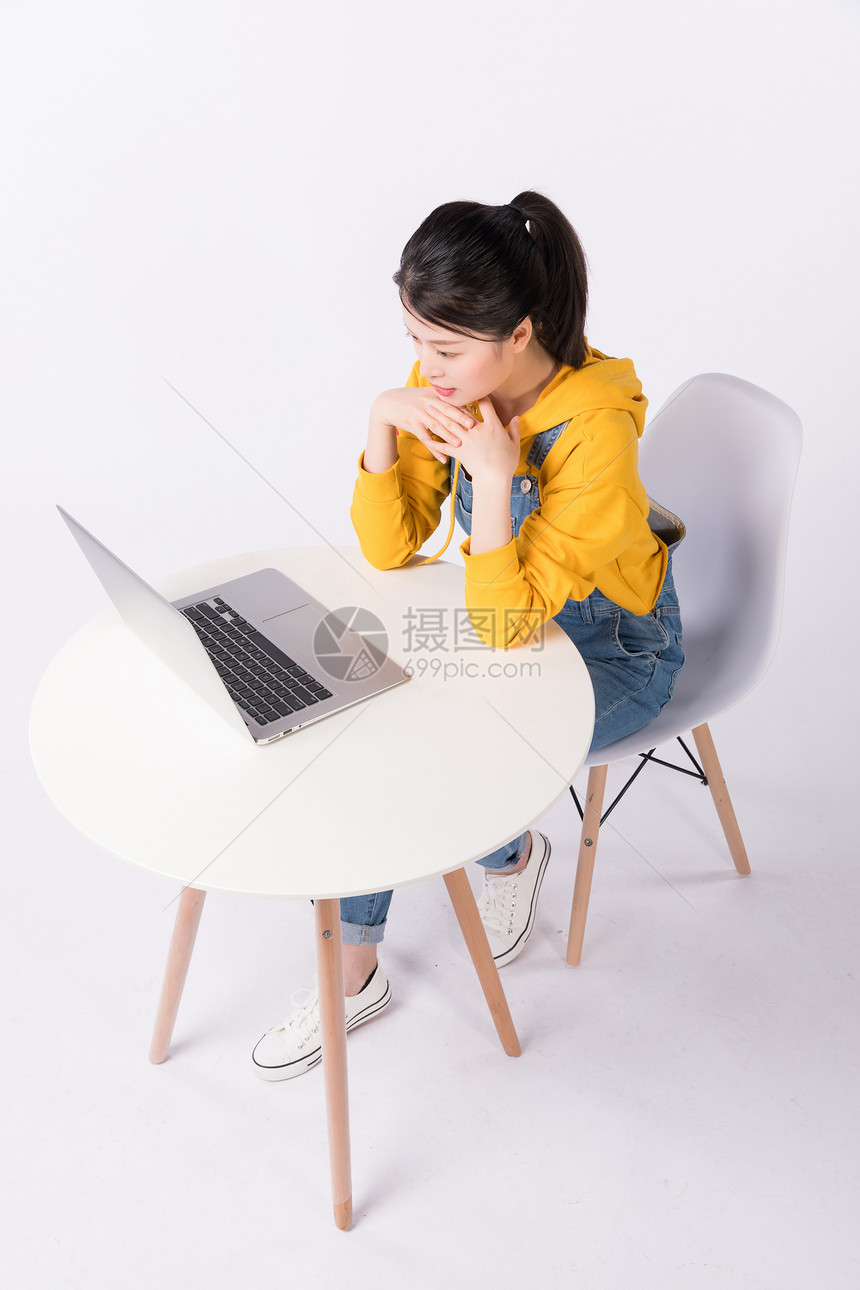 坐在椅子上使用电脑的学生图片