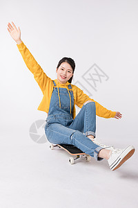 坐在滑板上的青春美少女图片坐在滑板上的青春美少女背景