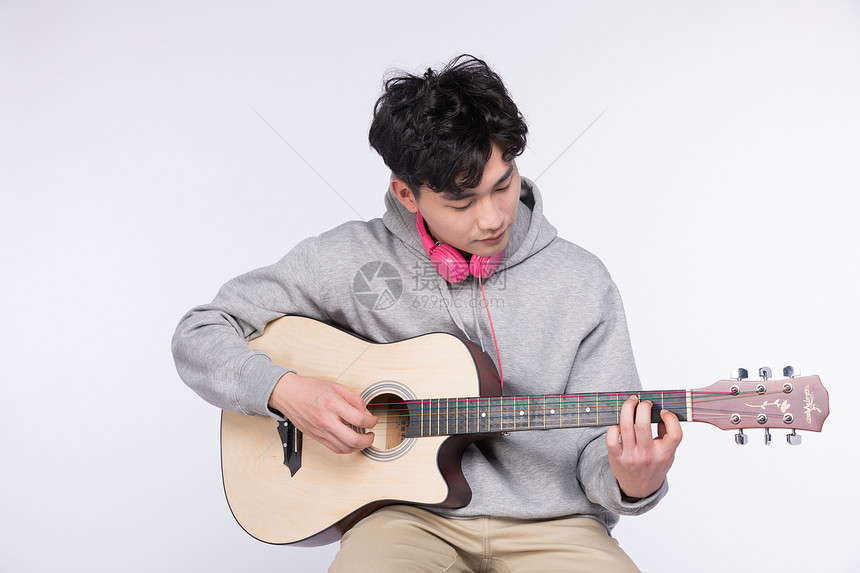 正在弹吉他的年轻男生图片