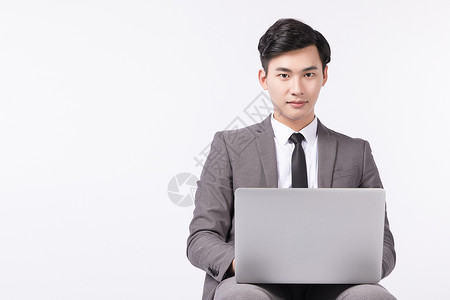 坐着操作电脑办公的商务男性图片