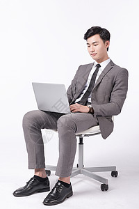 坐着操作电脑办公的商务男性背景图片