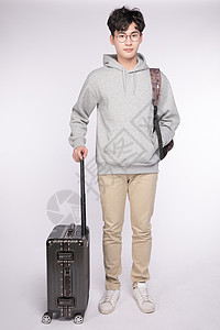 拉着行李箱背着书包的男生背影拉着行李箱背着书包的男生背景