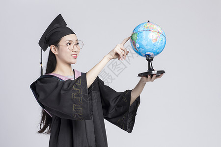 女生服装拿着地球仪的毕业女大学生背景