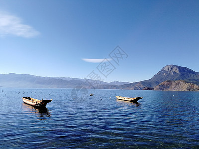 两只船儿漂浮在静静的湖面背景图片