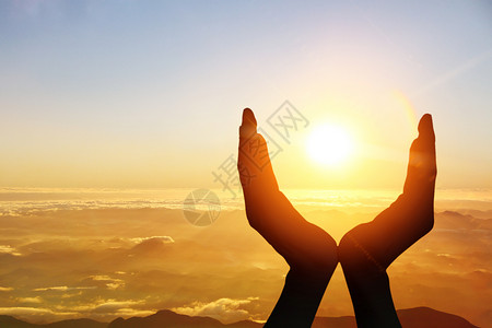 双手托起升起的太阳背景图片