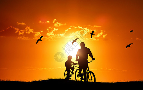 骑着父亲的孩子夕阳下父子剪影设计图片