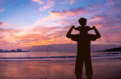 海边沙夕阳下海边散步的父女设计图片