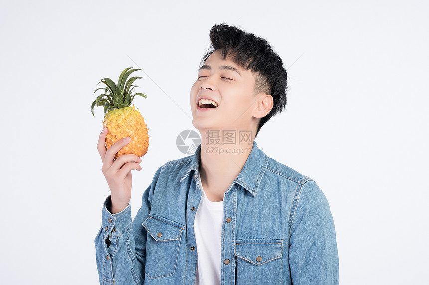 手持菠萝的青年男性图片