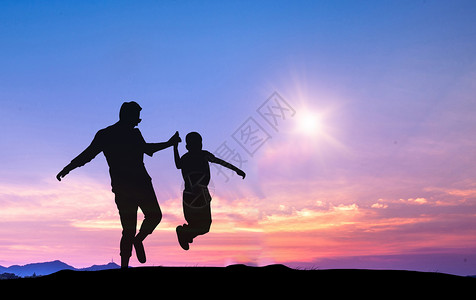 跳跃小孩夕阳下父子剪影设计图片