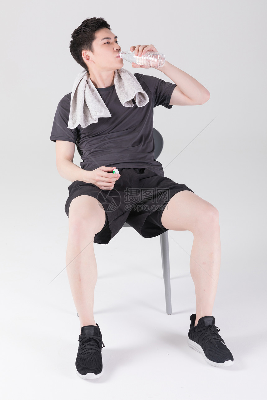 健身运动后休息喝水的男性图片